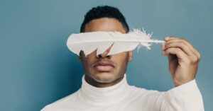 A man covered his eyes with white feather