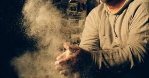Man Coating His Hands in Powder Chalk