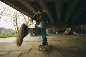A skateboard boy skates under the bridge