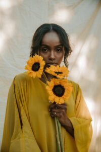 Black woman in yellow shirt with sunflowers