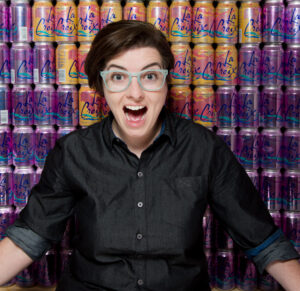 SK standing by a La Croix wall,