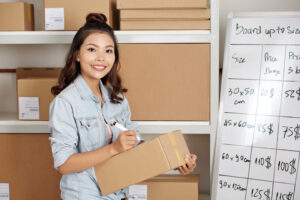 Woman calculating shipment costs on a white board.
